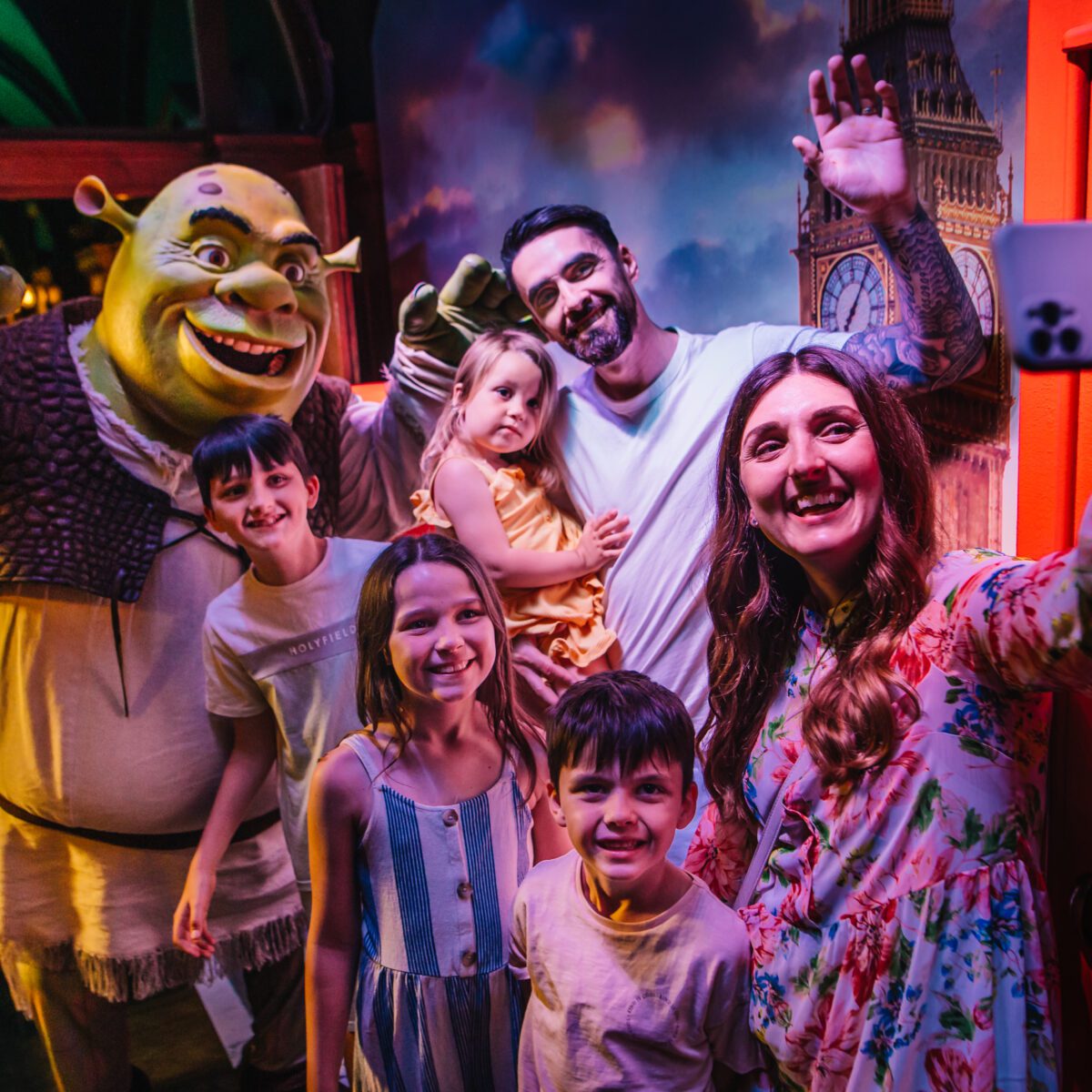 A family talking a group selfie with Shrek.