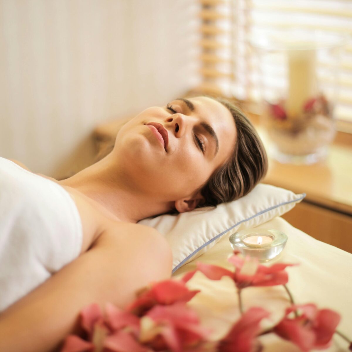 Woman in Wrapped in White Towel Lying on Bed with Eyes Closed